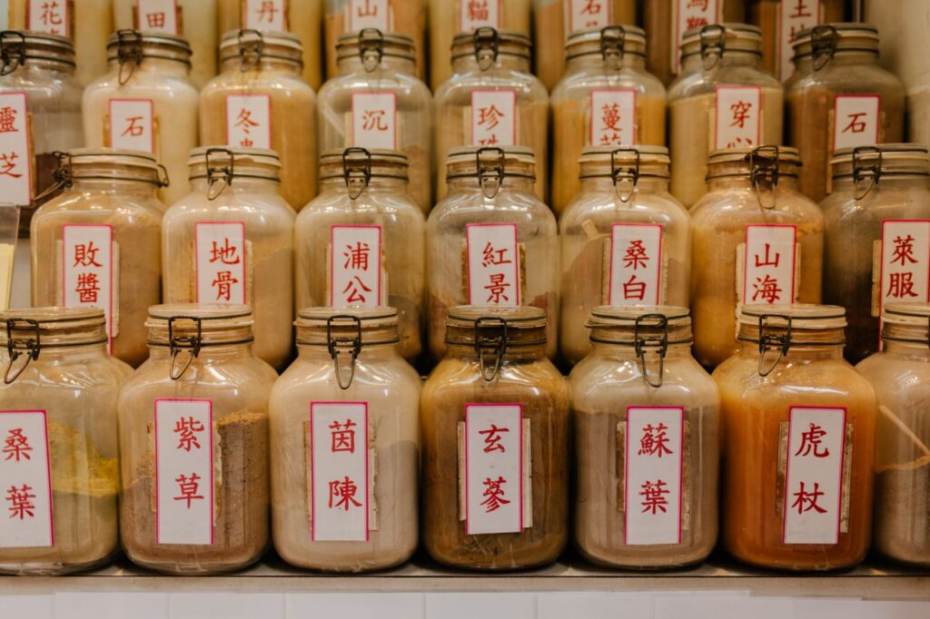 A variety of herbal medicine jars with Chinese labels displayed in a shop.